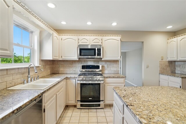 2337 Eastwind Dr, Beavercreek, OH 45434 - kitchen featuring appliances with stainless steel finishes, a sink, backsplash, recessed lighting, and light stone counters