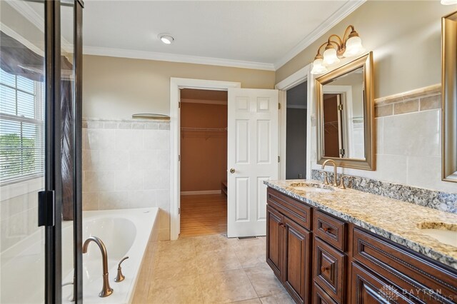 2337 Eastwind Dr, Beavercreek, OH 45434 - full bathroom with tile walls, tile patterned flooring, double vanity, a relaxing tiled tub, and ornamental molding