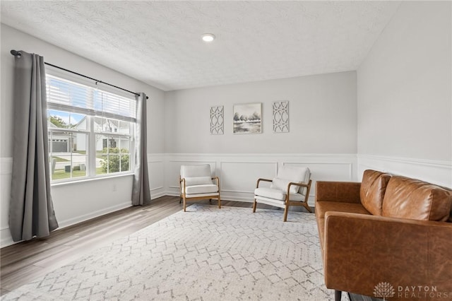 sitting room featuring wood finished floors and wainscoting