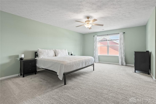 bedroom with baseboards, carpet flooring, a textured ceiling, and a ceiling fan
