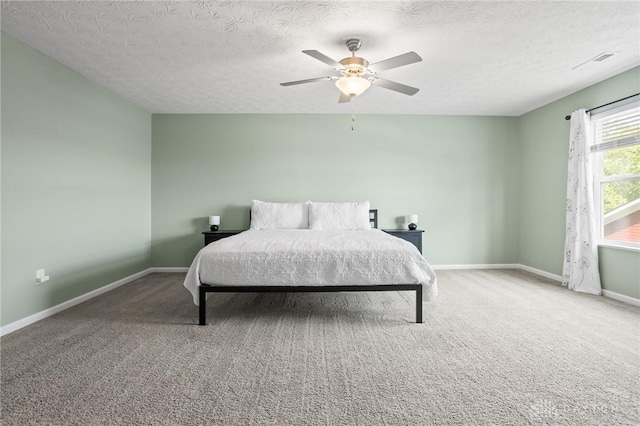 carpeted bedroom featuring a textured ceiling, baseboards, and ceiling fan