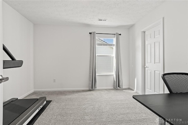 workout room featuring carpet floors, baseboards, and a textured ceiling