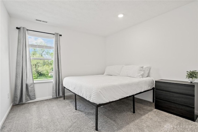 carpeted bedroom featuring baseboards and recessed lighting