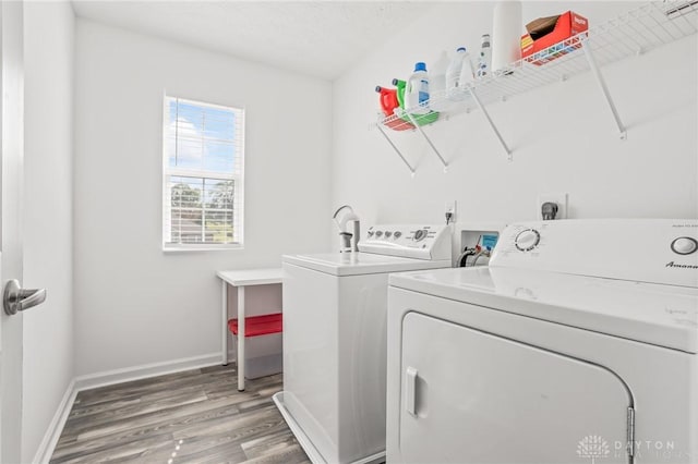 laundry room with washing machine and clothes dryer, light wood finished floors, and baseboards