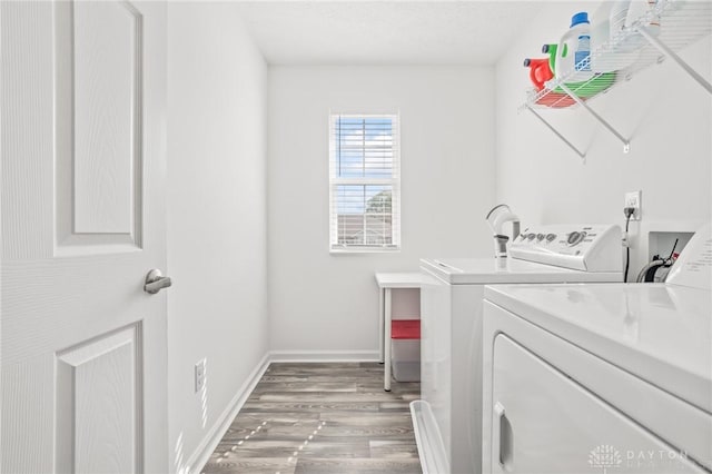 laundry room with independent washer and dryer, wood finished floors, and baseboards