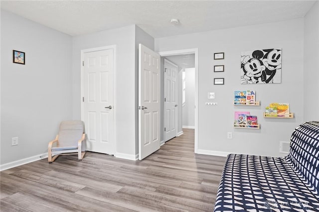 bedroom featuring wood finished floors and baseboards
