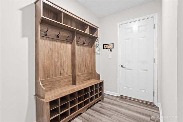 mudroom featuring wood finished floors and baseboards