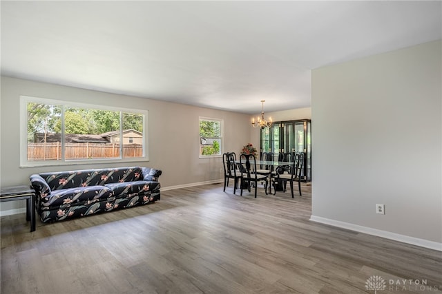 living room with a chandelier, wood finished floors, and baseboards
