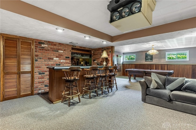 indoor dry bar with carpet flooring, billiards table, wooden walls, and a wainscoted wall