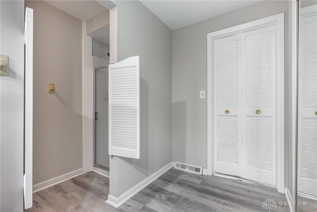 unfurnished bedroom with wood finished floors, baseboards, and a closet