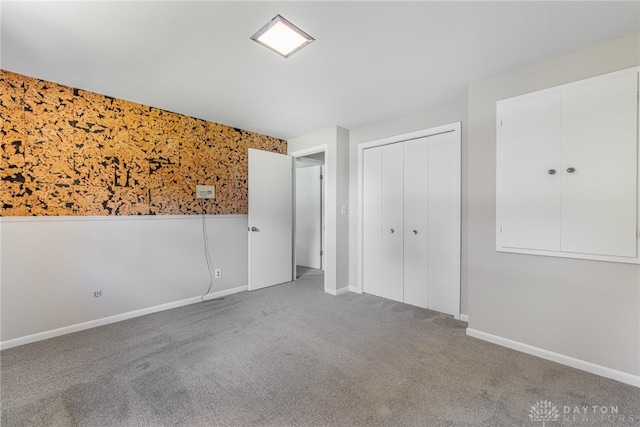 unfurnished bedroom with carpet flooring, baseboards, and a closet