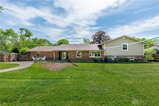 back of property with cooling unit, brick siding, and a patio