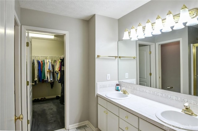 4826 Beechwood Ln, Middletown, OH 45042 - full bathroom with double vanity, baseboards, a textured ceiling, and a spacious closet