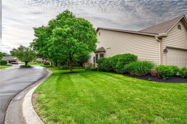 4826 Beechwood Ln, Middletown, OH 45042 - view of side of property featuring a lawn, a garage, and roof with shingles