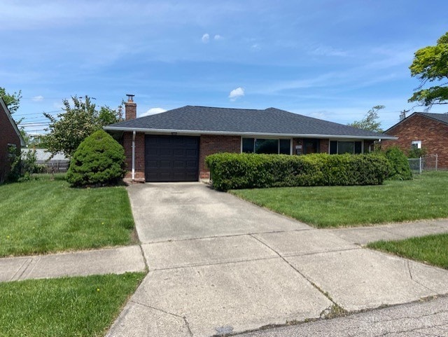 single story home with a garage, brick siding, concrete driveway, and a front yard