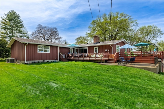 335 Winding Trl, Xenia Twp, OH 45385 - back of property featuring a wooden deck, board and batten siding, a chimney, central air condition unit, and a yard
