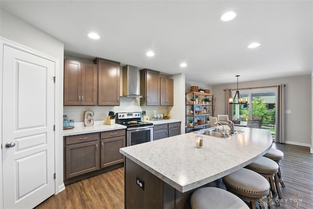 1535 Mulberry Ct, Turtlecreek Twp, OH 45036 - kitchen with electric range, wall chimney exhaust hood, a sink, dark wood finished floors, and a kitchen breakfast bar