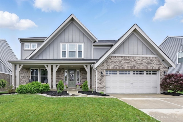1535 Mulberry Ct, Turtlecreek Twp, OH 45036 - view of front facade with board and batten siding, brick siding, driveway, a front yard, and a garage