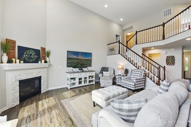 1535 Mulberry Ct, Turtlecreek Twp, OH 45036 - living area featuring a towering ceiling, stairs, wood finished floors, baseboards, and a stone fireplace