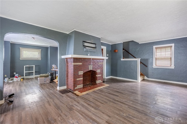 57 W Maplewood Ave, Dayton, OH 45405 - unfurnished living room featuring a textured wall, ornamental molding, wood finished floors, stairs, and arched walkways