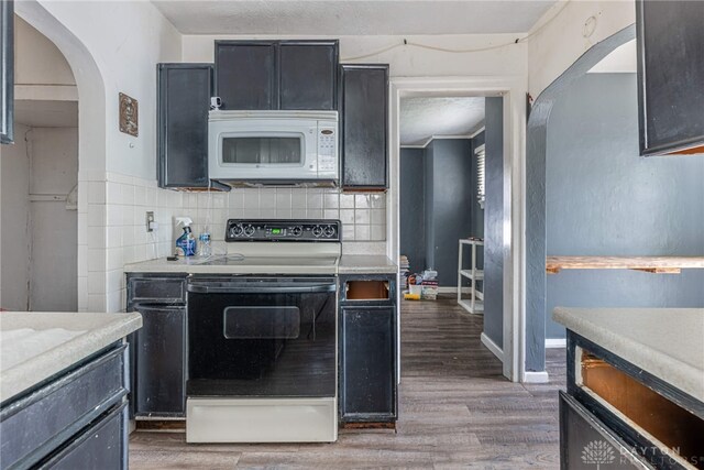 57 W Maplewood Ave, Dayton, OH 45405 - kitchen featuring range with electric stovetop, white microwave, arched walkways, and light wood finished floors