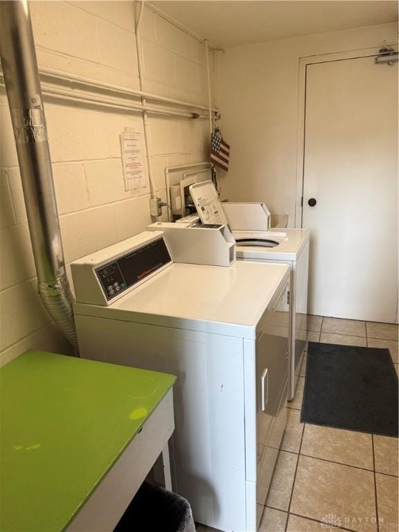 1109 Arrowhead Xing Unit A, West Carrollton, OH 45449 - community laundry room with washing machine and clothes dryer, concrete block wall, and light tile patterned floors