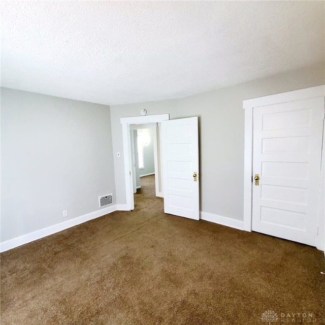 1271 Highland Ave, Dayton, OH 45410 - unfurnished bedroom with dark carpet and a textured ceiling