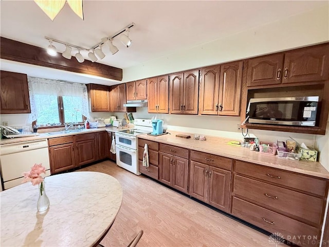 5778 Cedarwood Dr, Lewisburg, OH 45338 - kitchen featuring white appliances, under cabinet range hood, light countertops, light wood-style flooring, and a sink