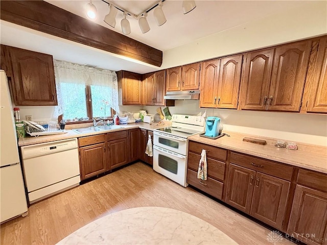 5778 Cedarwood Dr, Lewisburg, OH 45338 - kitchen featuring white appliances, a sink, under cabinet range hood, light countertops, and light wood-style flooring