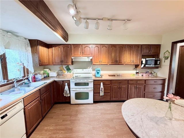 5778 Cedarwood Dr, Lewisburg, OH 45338 - kitchen featuring white appliances, a sink, under cabinet range hood, light countertops, and light wood-style flooring