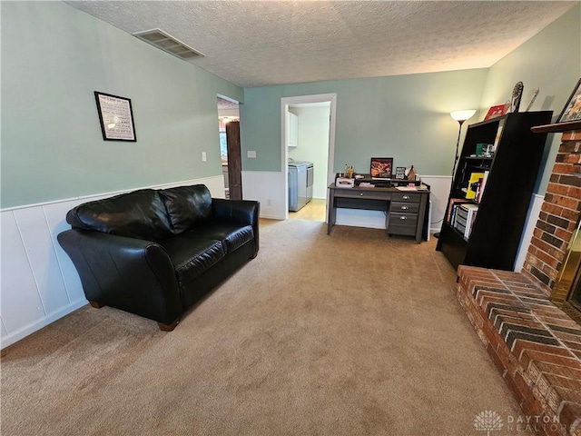 2547 Ryan Ct, Beavercreek, OH 45434 - living room featuring washer and clothes dryer, a textured ceiling, wainscoting, and light carpet