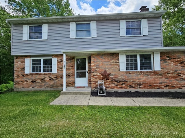 2547 Ryan Ct, Beavercreek, OH 45434 - colonial-style house featuring a front lawn, a chimney, a patio, and brick siding