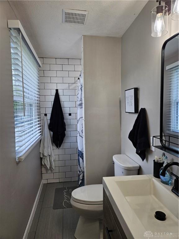 2547 Ryan Ct, Beavercreek, OH 45434 - bathroom featuring toilet, vanity, plenty of natural light, and a textured ceiling