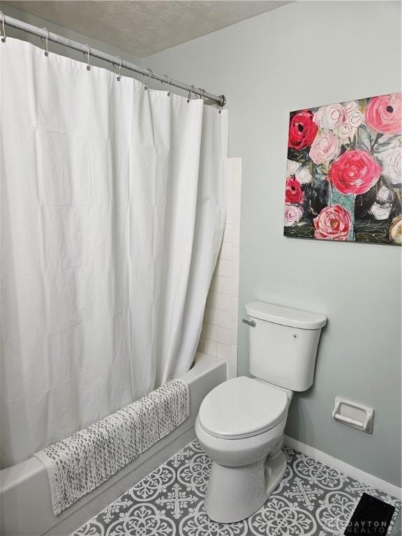 2547 Ryan Ct, Beavercreek, OH 45434 - full bath featuring shower / bathtub combination with curtain, toilet, tile patterned flooring, a textured ceiling, and baseboards