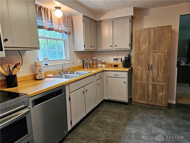 2547 Ryan Ct, Beavercreek, OH 45434 - kitchen featuring a sink, appliances with stainless steel finishes, light countertops, a textured ceiling, and dark floors