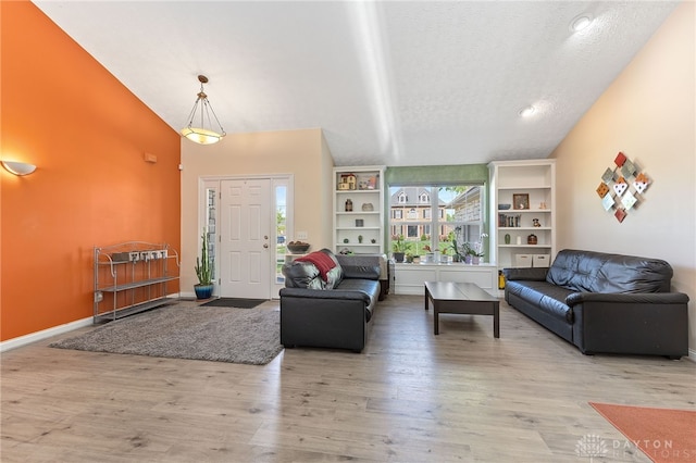 9300 Somerset Ct, Clearcreek Twp, OH 45458 - living area with wood finished floors, a textured ceiling, lofted ceiling, and baseboards