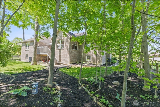 9300 Somerset Ct, Clearcreek Twp, OH 45458 - rear view of property with brick siding, a lawn, and stairs