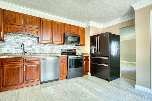 3339 Turner Dr, Springfield, OH 45504 - kitchen with stainless steel appliances, a sink, baseboards, backsplash, and light wood-style floors