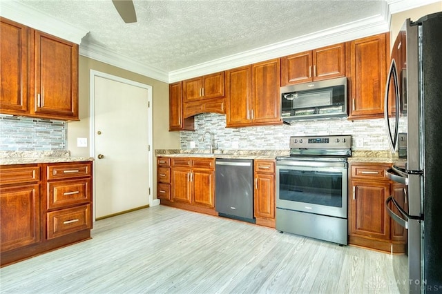 3339 Turner Dr, Springfield, OH 45504 - kitchen featuring stainless steel appliances, a sink, decorative backsplash, light wood-type flooring, and a textured ceiling