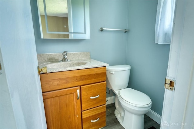 3339 Turner Dr, Springfield, OH 45504 - half bathroom with toilet, vanity, baseboards, and wood finished floors