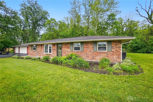 8590 Euphemia Castine Rd, Lewisburg, OH 45338 - view of front of home with brick siding, driveway, an attached garage, a front yard, and central AC unit