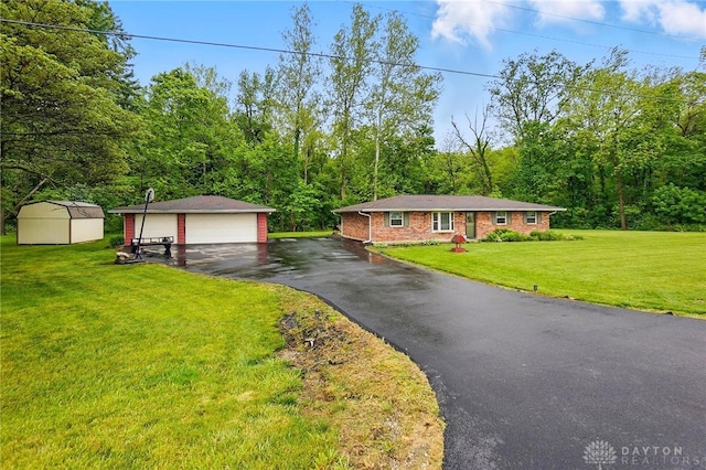 8590 Euphemia Castine Rd, Lewisburg, OH 45338 - ranch-style house featuring a garage, a front lawn, a forest view, and brick siding
