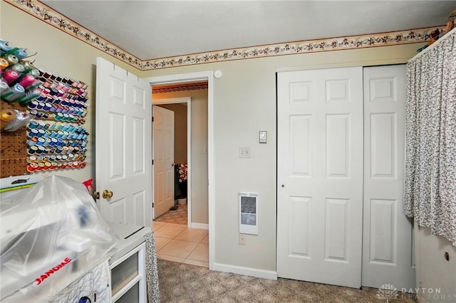 8590 Euphemia Castine Rd, Lewisburg, OH 45338 - bedroom featuring heating unit, a closet, light tile patterned flooring, baseboards, and light colored carpet