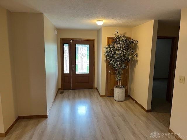 125 Honeysuckle Way, Eaton, OH 45320 - entryway featuring light wood-type flooring, baseboards, and a textured ceiling