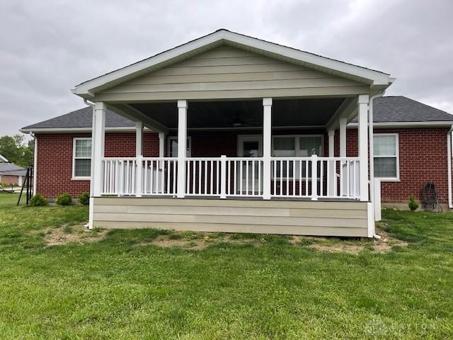 125 Honeysuckle Way, Eaton, OH 45320 - back of property featuring brick siding, a yard, and a porch