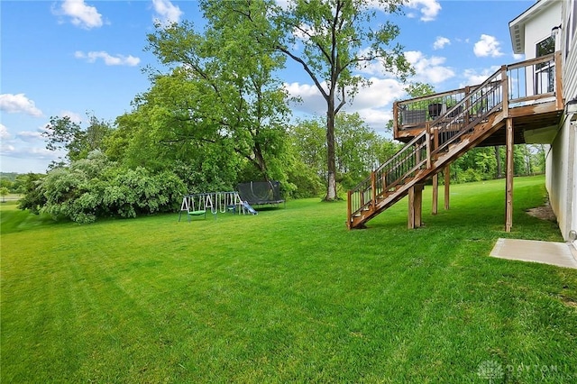 1691 Arden Bnd, Fairborn, OH 45324 - view of grassy yard featuring stairway, a trampoline, a playground, and a deck