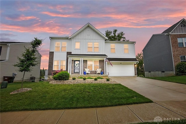 1691 Arden Bnd, Fairborn, OH 45324 - view of front of property with covered porch, driveway, board and batten siding, a garage, and a front yard