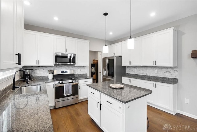 1691 Arden Bnd, Fairborn, OH 45324 - kitchen with stainless steel appliances, a sink, decorative backsplash, white cabinetry, and dark stone countertops