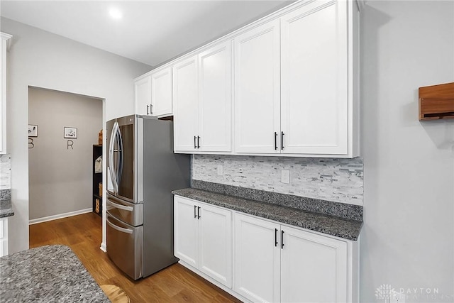 1691 Arden Bnd, Fairborn, OH 45324 - kitchen with freestanding refrigerator, light wood-style flooring, backsplash, white cabinetry, and dark stone countertops