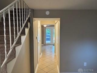 765 Clareridge Ln, Dayton, OH 45458 - corridor featuring light tile patterned flooring, baseboards, and stairway